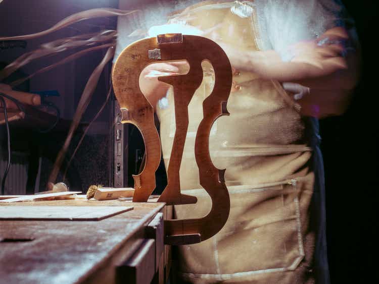 artisan violin maker luthier working with violin mould for center bot, corner blocks , bend ribs for a new classic handmade violin