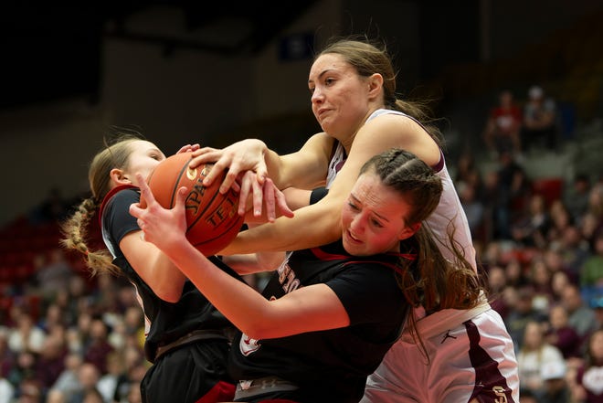 Silver Lake's Kaibryn Kruger (11) reaches for the ball against Hesston's Kendal Brueggen (3) and Jaden Williams (2) during State Basketball Championships March. 9, 2024 at Hutchinson Sports Arena.