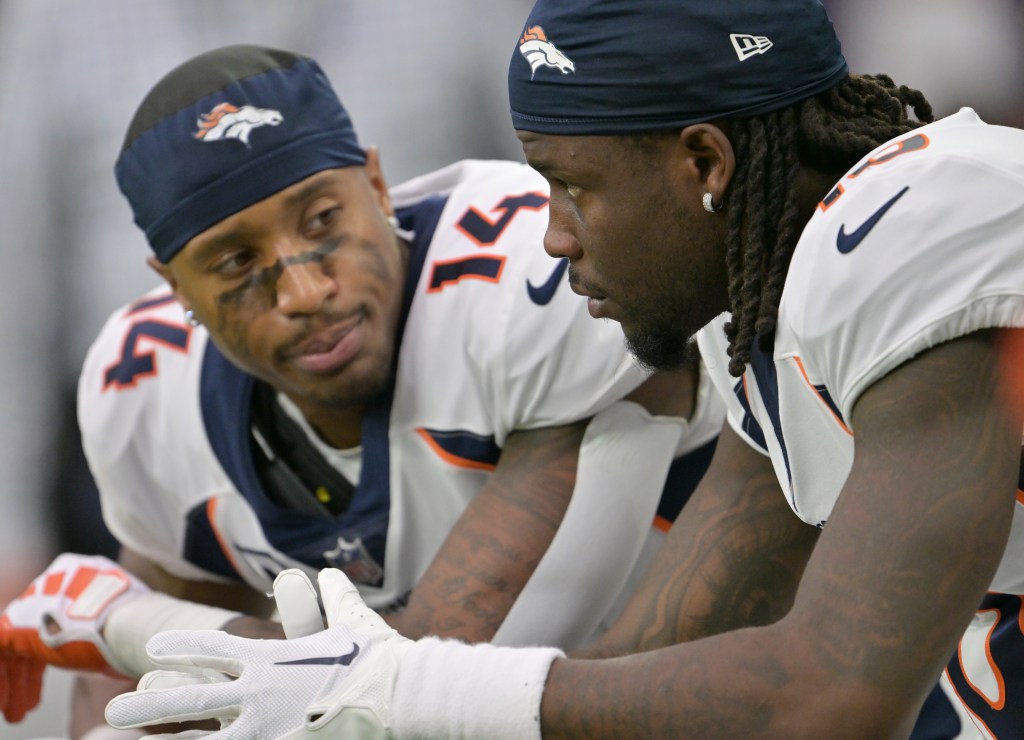 Courtland Sutton (14), left, and teammate wide receiver Jerry Jeudy (10) talk on the bench at NRG Stadium in Houston, Texas on December 3, 2023. 