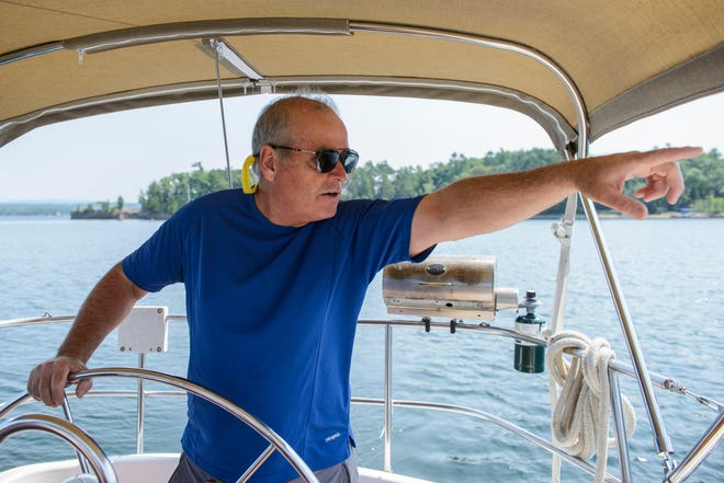Real Estate agent Chris Von Trapp points to a house during a tour of the waterfront real estate along the shores of Lake Champlain on Friday afternoon August 24, 2018 in Shelburne Bay.