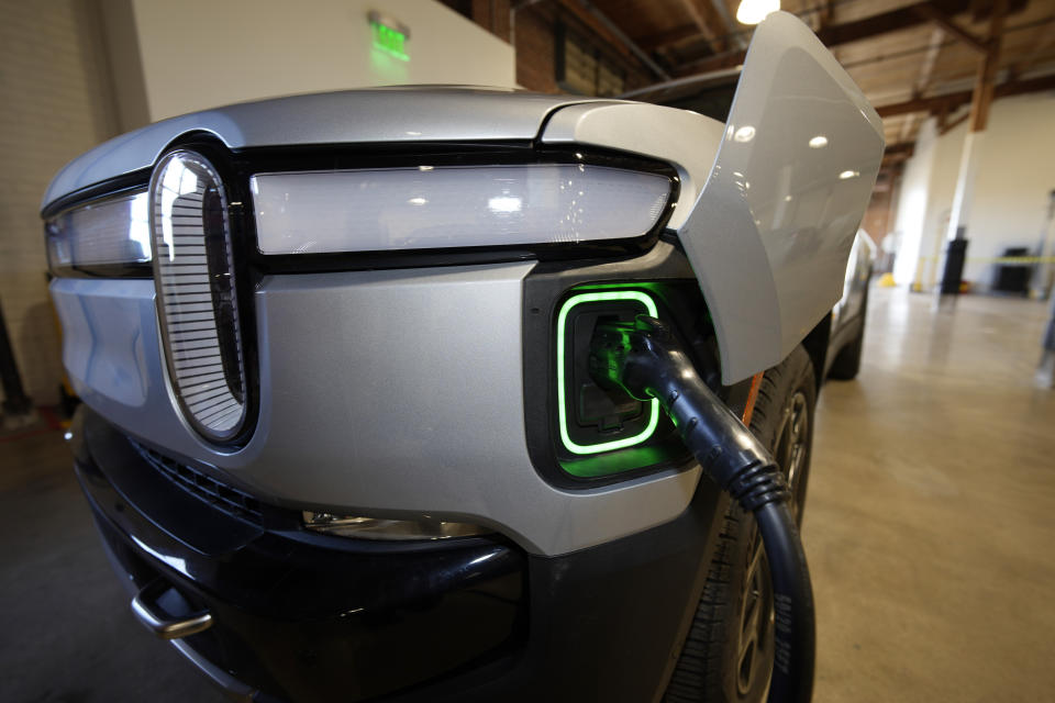 A 2023 R1T pickup truck is charged in a bay at a Rivian delivery and service center Wednesday, Feb. 8, 2023, in Denver. (AP Photo/David Zalubowski)