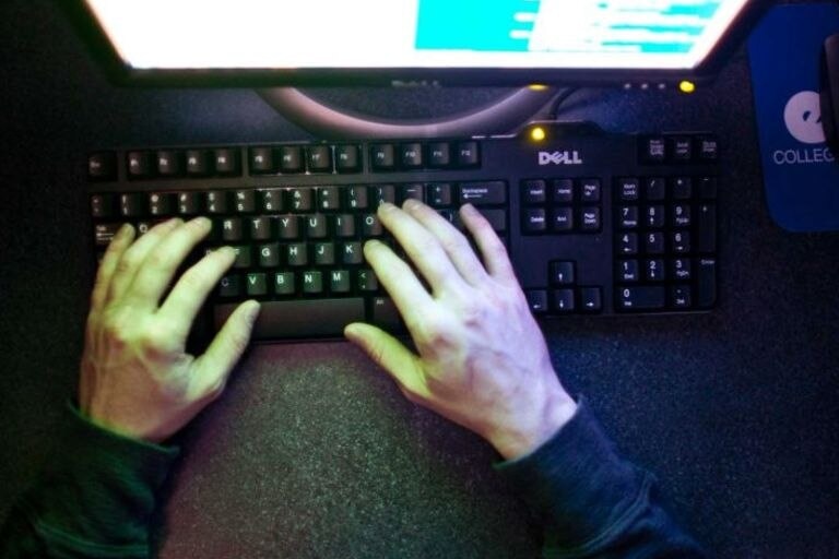 hands typing on a computer keyboard.