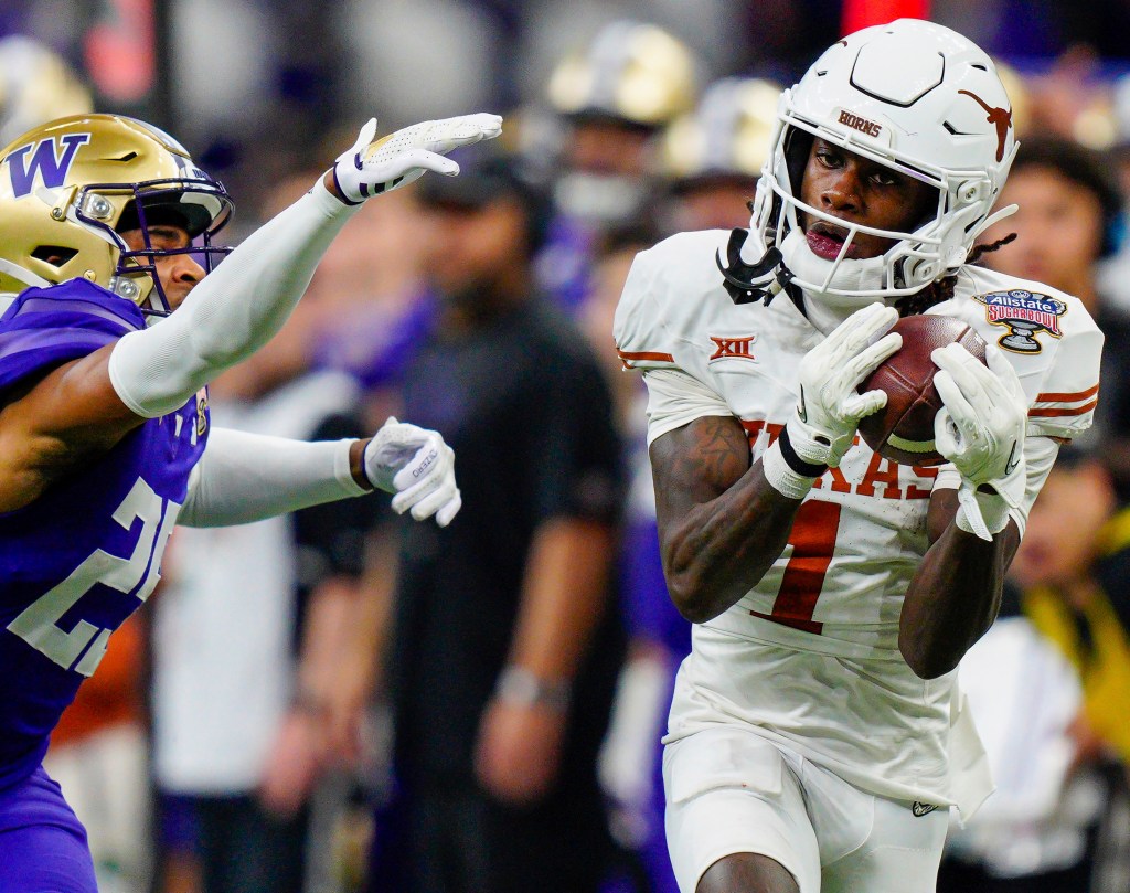 Texas wide receiver Xavier Worthy (1) makes a catch while covered by Washington cornerback Elijah Jackson, left, during the Sugar Bowl CFP NCAA semifinal college football game Jan. 1, 2024
