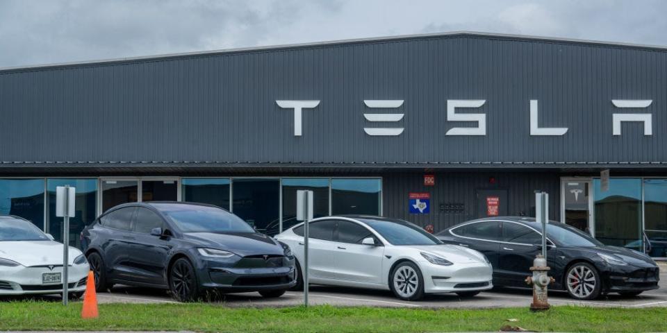 Tesla vehicles sitting on the lot at a Tesla dealership.