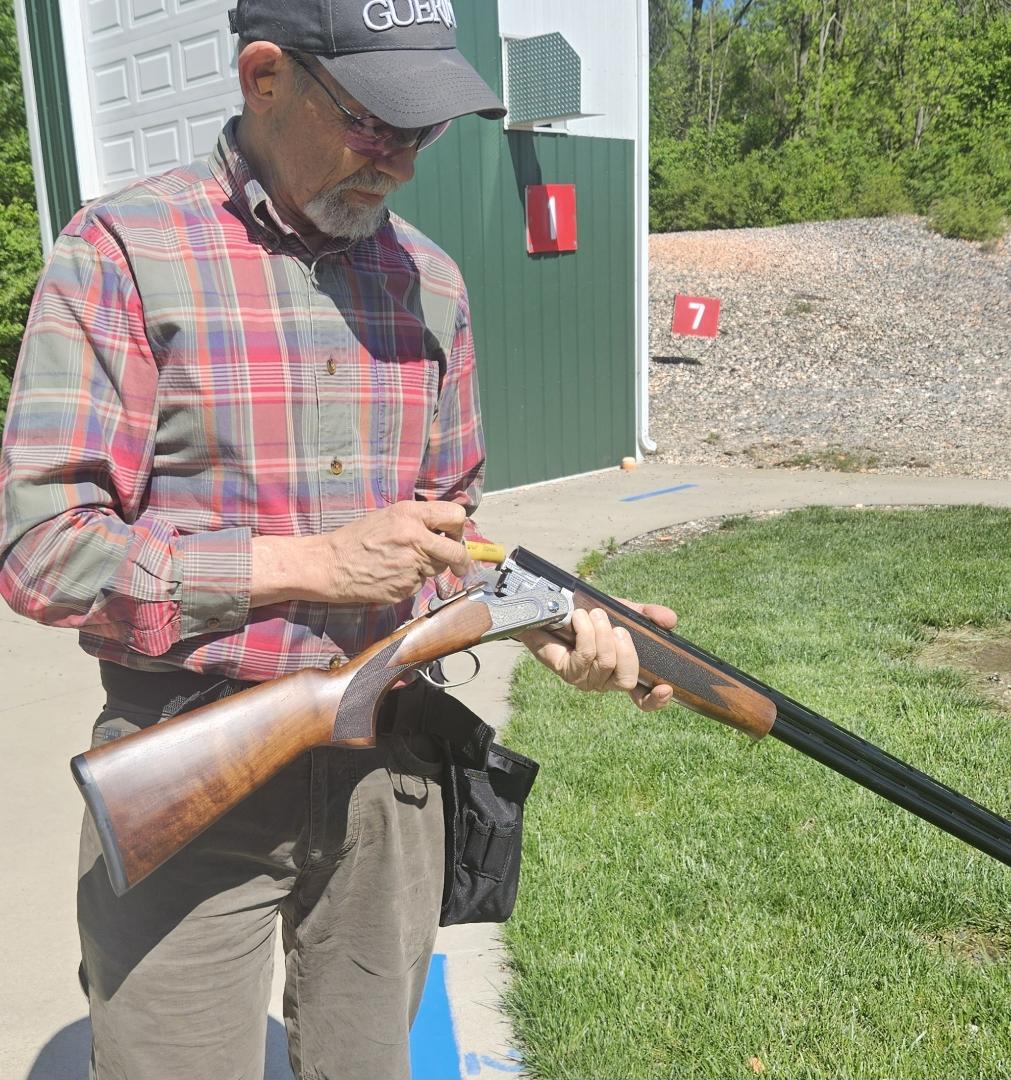 Shooter loads Mossberg's newest 20-gauge sporing shotgun on the range.