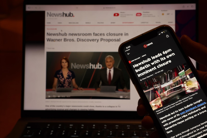 Newshub homepage is displayed on a laptop, alongside a news article on the networks pending closure on an iPhone 