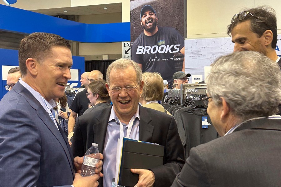 Berkshire Hathaway investment manager Ted Weschler, center, talks with Brooks Running CEO Dan Sheridan, Friday, May 3, 2024, in Omaha, Neb., one day ahead of the annual shareholders meeting. (AP Photo/Josh Funk)