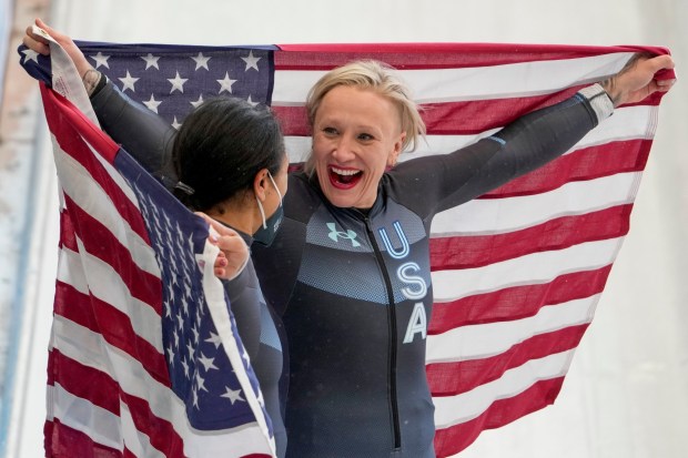 Kaillie Humphries, right, and American teammate Elana Meyers Taylor celebrate winning the gold and silver medals in the women's monobob at the 2022 Winter Olympics in Beijing. (Pavel Golovkin/AP)